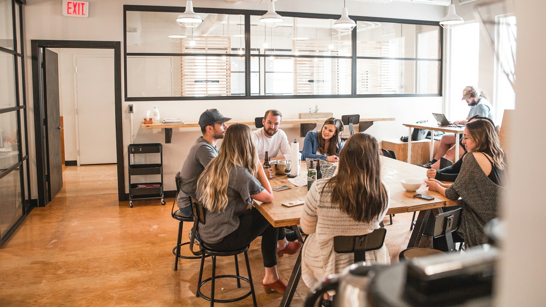 A group talking around a table in a sunlit café